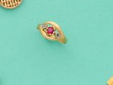 trois bagues en or et une paire de boucles d'oreilles sur fond turquoise
