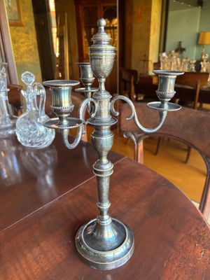 un candélabre en argent posé sur une table en bois dans une salle à manger