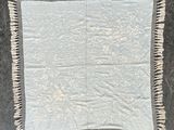 une image représentant une nappe blanche ornée de franges
