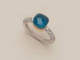 gros plan d'une bague avec une pierre bleue et des diamants