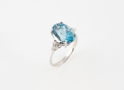 une bague sertie d'une topaze bleue et de diamants sur fond blanc