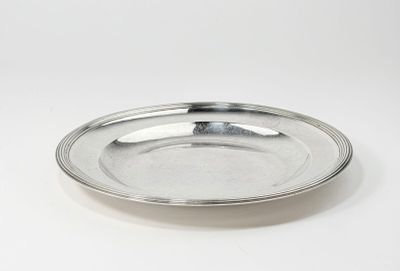 une image représentant une assiette en argent posée sur une surface blanche