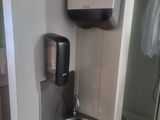 une salle de bains équipée d'un lavabo et d'un sèche-mains fixé au mur