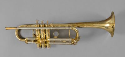 an old brass trumpet sitting on top of a white surface