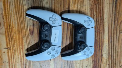 deux manettes de jeux vidéo posées sur une table en bois