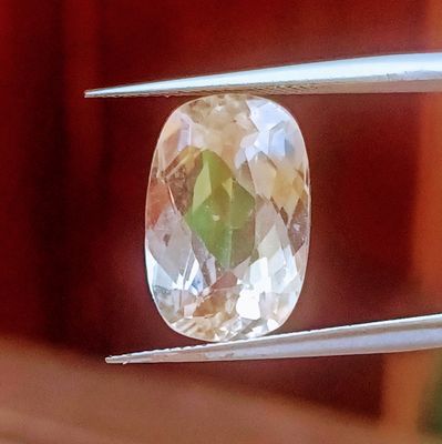 un gros plan d'un diamant tenu par une pince