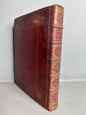 un vieux livre rouge posé sur une table blanche