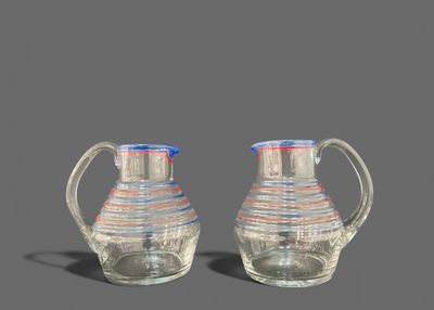 une paire de cruches en verre transparent aux bords rouges, blancs et bleus