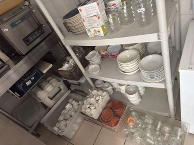 many dishes and cups on the shelves in the kitchen