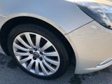 a close up of a silver car parked in a parking lot