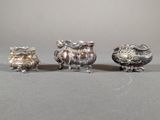 three silver figurines sitting on top of a table next to each other