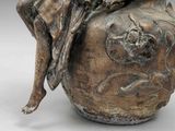 a statue of a woman sitting on top of a vase