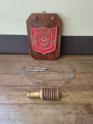a wooden plaque with a chain around it on a table