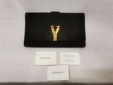 a black purse with a gold y on it sitting next to a business card