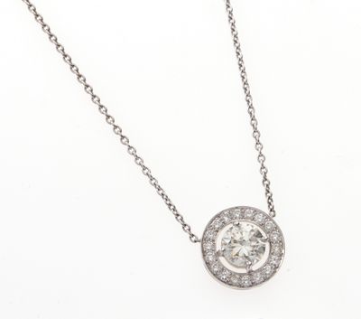 un collier avec un pendentif en or blanc et diamants