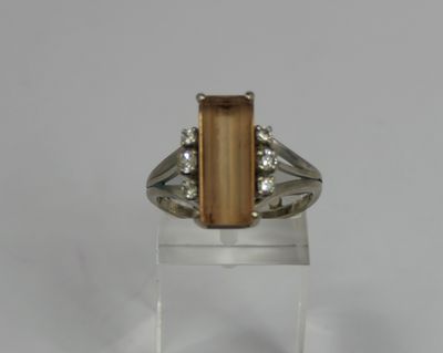 a close up of a ring with a stone and diamonds on it