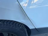 a close up of a car ' s tire with a mountain in the background