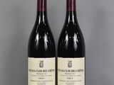 two bottles of wine sitting on top of a table next to each other