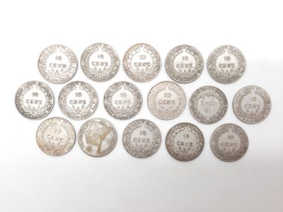 Plusieurs pièces d'argent sont disposées en rangée sur une surface blanche