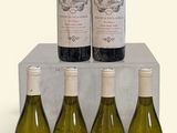six bottles of wine sit in a display case on a white surface