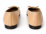beige leather shoes with black soles on a white surface