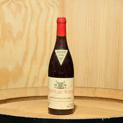 une bouteille de vin posée sur un tonneau en bois