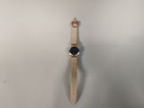 a close up of a watch hanging on a wall with a white background