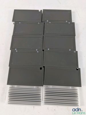 un gros plan sur une pile de lecteurs de disquettes posés sur une surface blanche