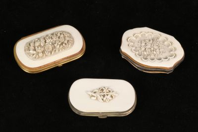 three pieces of white and gold jewelry sitting on a black surface