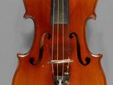 an old violin with a bow hanging on a wall