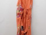 an orange dress hanging on a hanger on a white wall