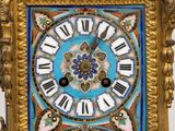 a gold clock with a blue and white design on it