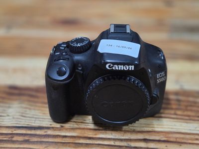 a canon camera sitting on a wooden table