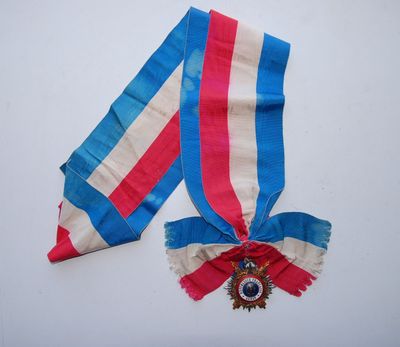 un ruban rouge, blanc et bleu et une médaille sur un fond blanc