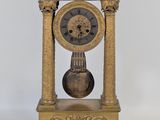 une horloge en or posée sur un socle en bois