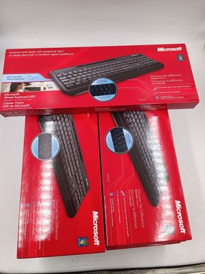 deux boîtes contenant un clavier et une souris sans fil Microsoft posées sur une surface blanche