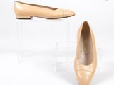 une paire de chaussures couleur chair sur un présentoir en acrylique transparent