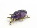 une image représentant un insecte violet posé sur une surface blanche
