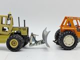 two toy tractors that are sitting side by side on a white surface