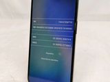 the back of a black phone with a blue screen on a white surface