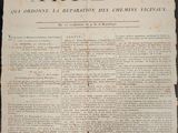 un vieux journal sur lequel est posé une grande feuille de papier