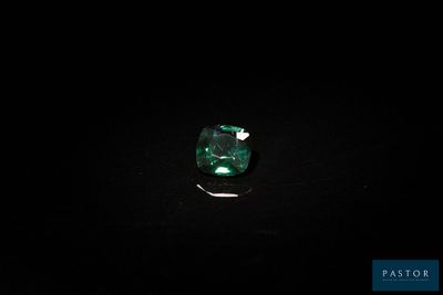 a close up of a green emerald stone on a black surface
