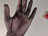 a person ' s hand wearing a black glove and a bracelet