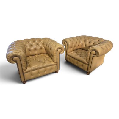 deux chaises en cuir marron assises l'une à côté de l'autre sur une surface blanche