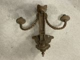 an old iron hook on the wall with two candles