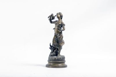 statue en bronze représentant une femme tenant un oiseau, sur fond blanc