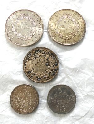 Quatre types de pièces différents sont représentés sur une feuille de papier