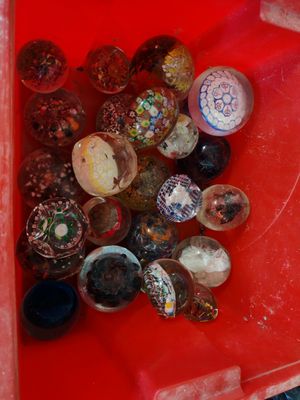 a red container filled with lots of different types of beads