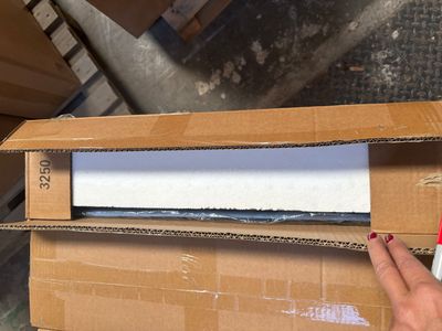 a person holding a box with a piece of paper in it