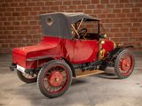 a red and black model t car parked in front of a brick wall